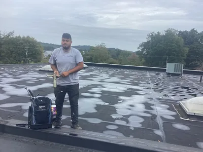 Ponding water standing on an aging commercial flat roof before repair