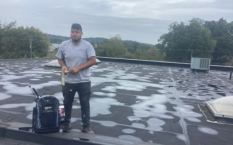 Ponding water standing on an aging commercial flat roof before repair