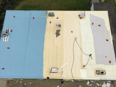 Commercial roof restoration in progress showing the base, foam and finish coat stages