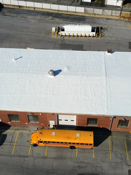 Restored white metal roof on a school bus depot